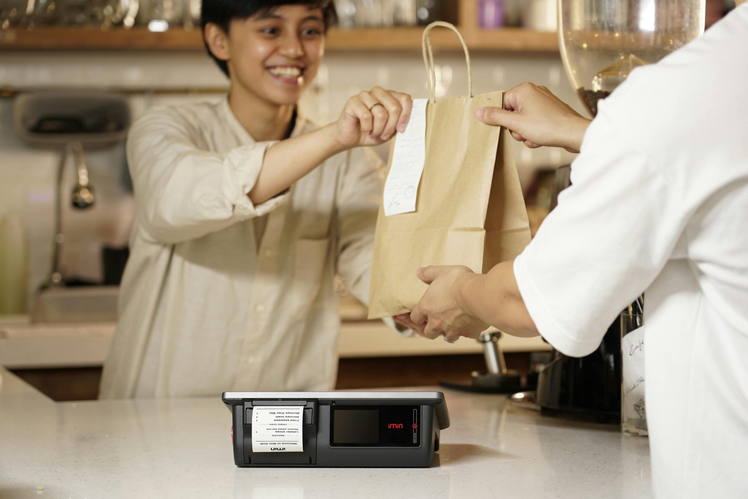 A salesperson handing a paper bag to a customer in a retail setting as part of direct sales.